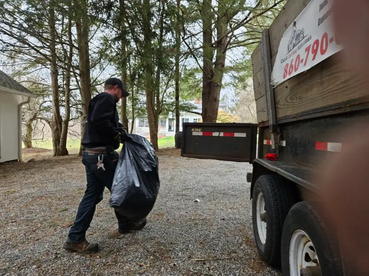 a person holding a trash with a truck in right side